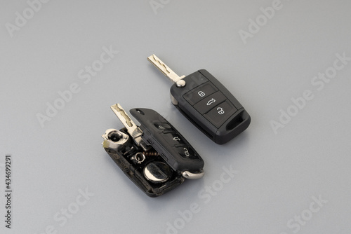 Broken Or Damaged Car Key Fob And New Remote Vehicle Key On Grey Background. Repair Of Broken Or Damaged Remote Key Fob Of Any Vehicle Car Service.