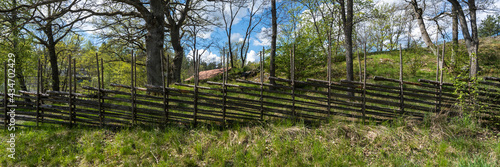 Old traditional swedish wooden fence. Vintage style hedge. Countryside farm authentic cozy hand made wooden fence palisade in a rural area. Scandinavian rural houses interior details.