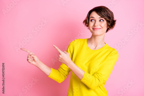 Photo of young beautiful smiling happy positive dreamy girl pointing fingers copyspace isolated on pink color background