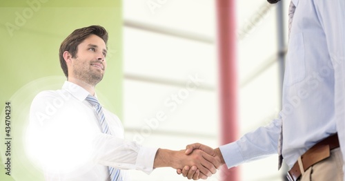 Composition of businessmen shaking hands in office