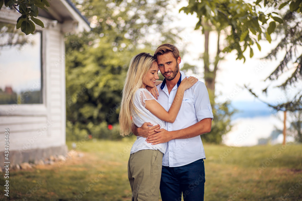 Fototapeta premium Young couple standing in backyard.