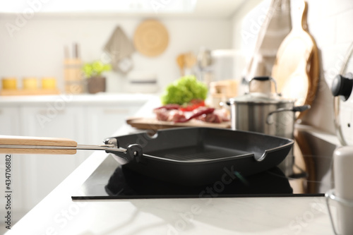 Frying pan with cooking oil on cooktop in kitchen © New Africa