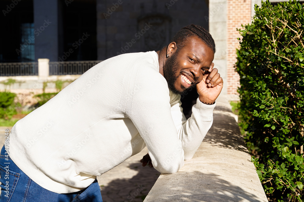 Young African American man smiling leaning against a wall, Happy Latino man. Young African American man smiling leaning against a wall, Happy Latino man.