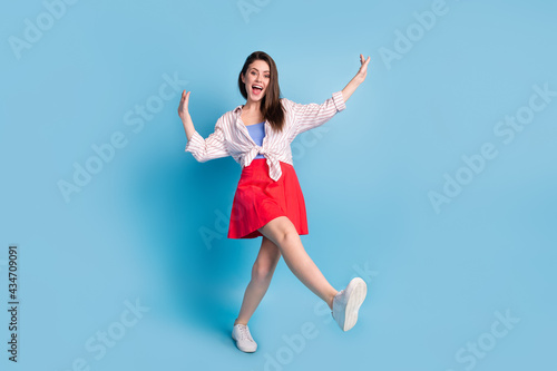 Full length body size view of attractive funky cheerful slim carefree girl dancing having fun isolated over bright blue color background
