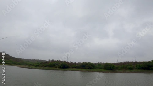 Time lapse of the clouds above the Vadsar lake with windmill in background during the monsoon season at Wankaner, Gujarat, India photo