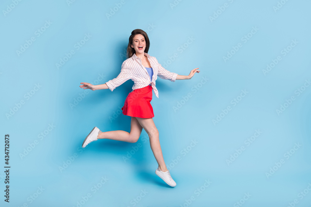 Full body profile portrait of energetic cheerful girl rush toothy smile look camera isolated on blue color background Full body profile portrait of energetic cheerful girl rush toothy smile look camera isolated on blue color background