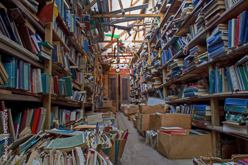 An old abandoned library. Book background. Books on the bookshelf. Knowledge in paper form