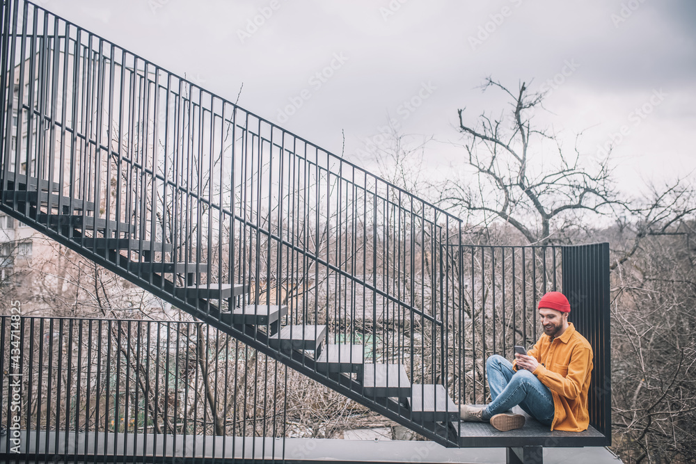 Man sitting on the steps of the city bridge