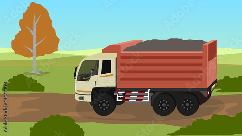 Dump trucks drive on dirt roads in natural areas. Packed with soil. Vast grassland scenery.