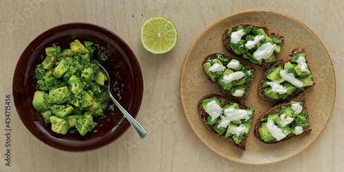 Preparing sandwiches with guacamole avocado spread and tahini and yoghurt dressing.