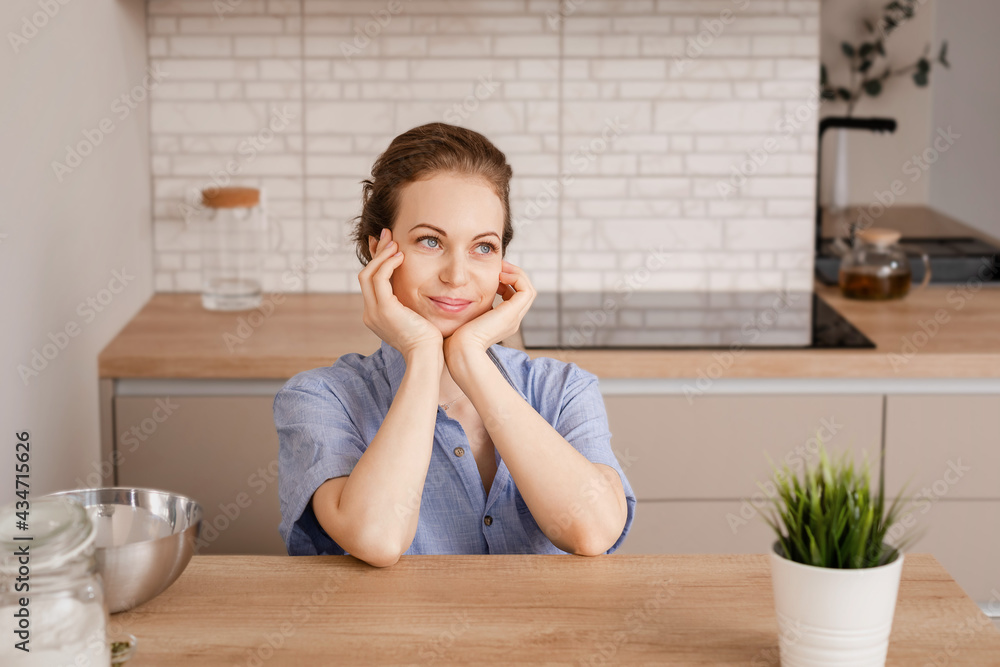 Portrait of young thinking female on kitchen interior background. Looking aside. Portrait of young thinking female on kitchen interior background. Looking aside.