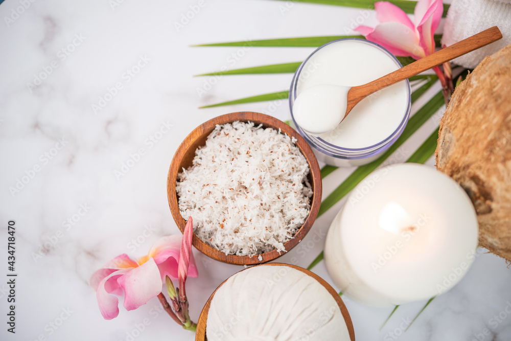 Coconut oil, tropical leaves and fresh coconuts. Spa coconut products on light wooden background. Spa still life of organic cosmetics with coconuts on a light wooden background, body care concept. Coconut oil, tropical leaves and fresh coconuts. Spa coconut products on light wooden background. Spa still life of organic cosmetics with coconuts on a light wooden background, body care concept.
