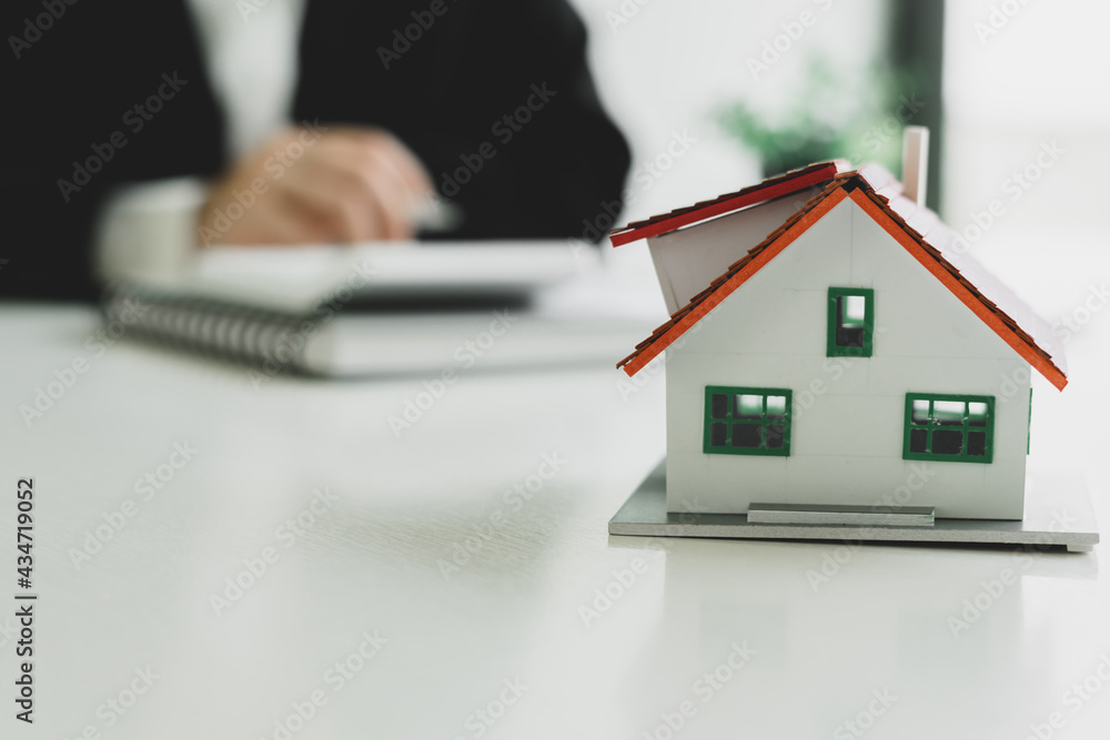Home agents are using a calculator to calculate the loan period each month for the customer. Home agents are using a calculator to calculate the loan period each month for the customer.