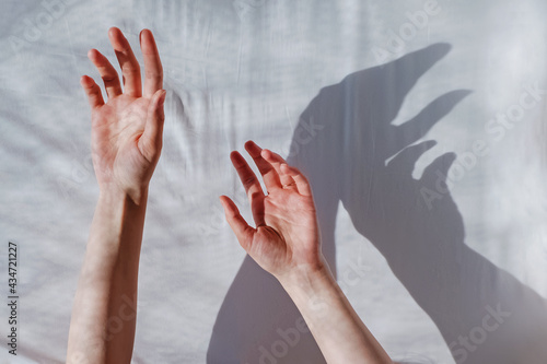 Woman's hand reaching out on white cloth background.