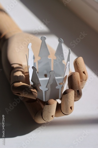 wooden hand holding a crown candle holder