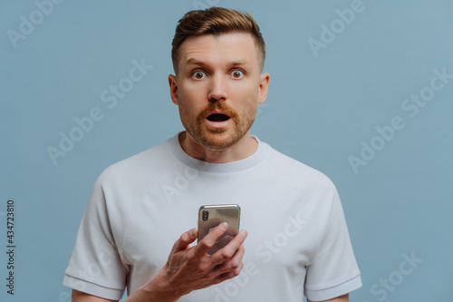Photos Surprised man reading unexpectable news on mobile phone