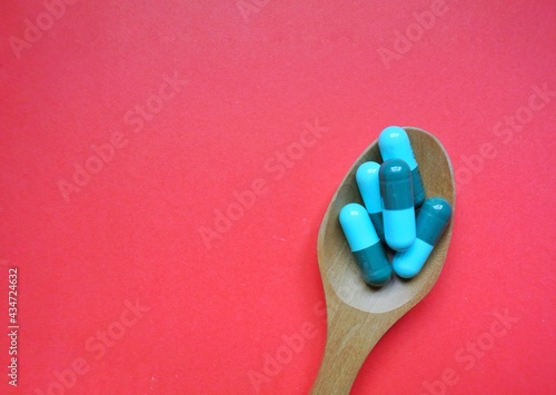 Tablets on a wooden spoon.Antibiotics. photo