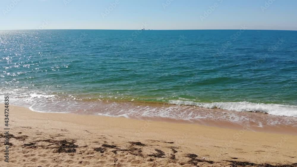 Aerial top view of ocean blue waves crashing on the beach. Sea waves and beautiful sandy beach aerial view shot from a drone. Aerial top view of ocean blue waves crashing on the beach. Sea waves and beautiful sandy beach aerial view shot from a drone.