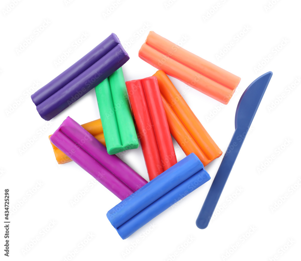 Many different colorful plasticine pieces and sculpting knife on white background, top view Many different colorful plasticine pieces and sculpting knife on white background, top view