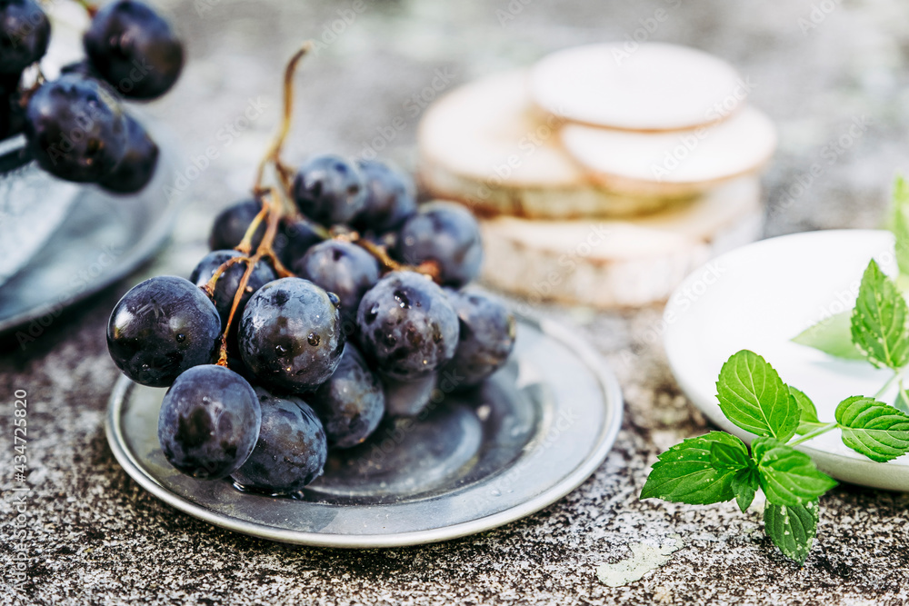 Grappe de raisin noir fraichement cueillis dans la vigne posé sur une table texturé