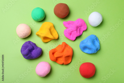 Foto Colorful plasticine on green background, flat lay