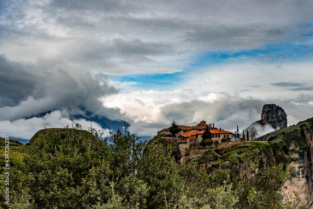 Greece, Meteora, green panoramic landscape with one of the monasteries. Impressive dramatic sky.