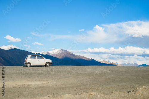 White car parking at Pangong Lake in Ladakh, India. Pangong is an endorheic lake in the Himalayas situated at a height of about 4,350 m.