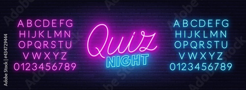 Quiz Night neon sign on brick wall background.
