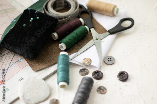 Creative image of seamstress ribbon tools, thimble and scissors for sewing on an old wooden surface. Concept. Selective focus.