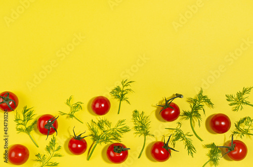 Fresh red tomato and green dill with shadow as border on yellow background, modern food pattern, top view.