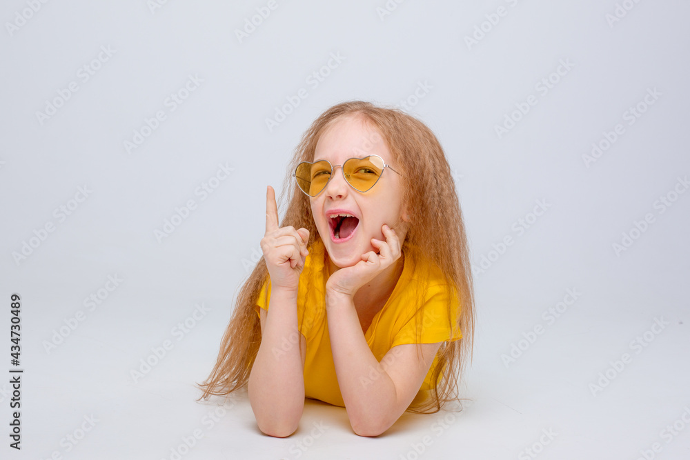 a little girl lying on a white background shows emotions