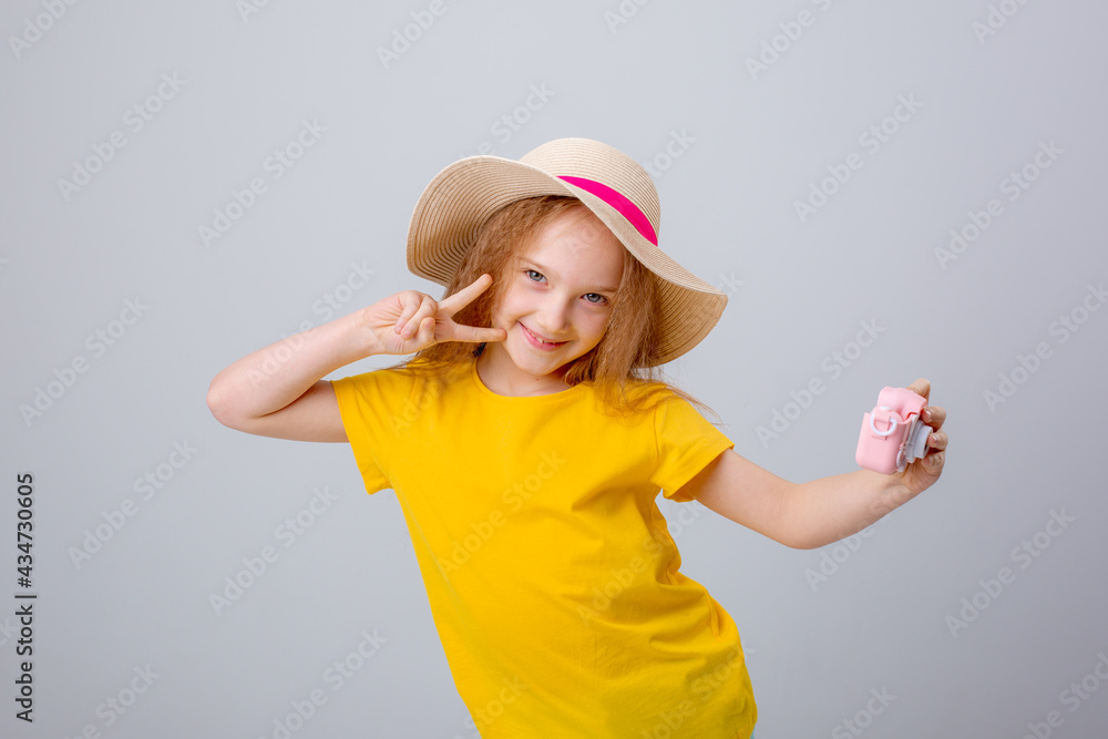little girl in hat traveler holds a camera on a white background little girl in hat traveler holds a camera on a white background