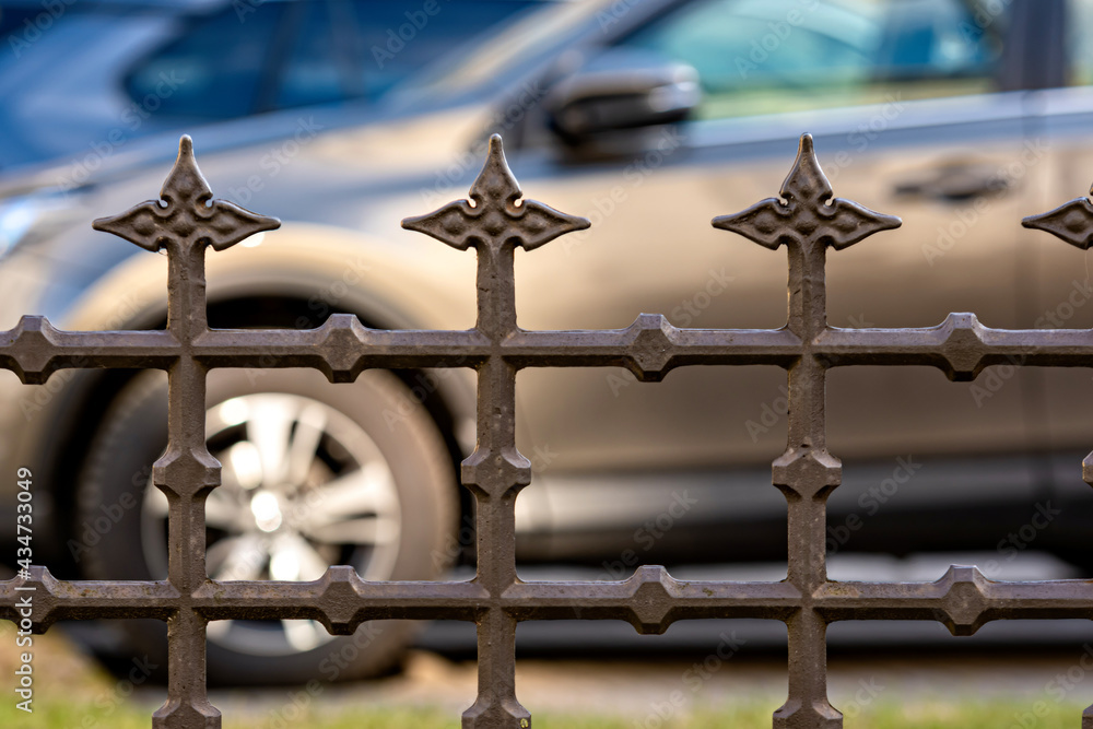 view through a metal fence on cars in parking, selective focus, focus on fencing view through a metal fence on cars in parking, selective focus, focus on fencing