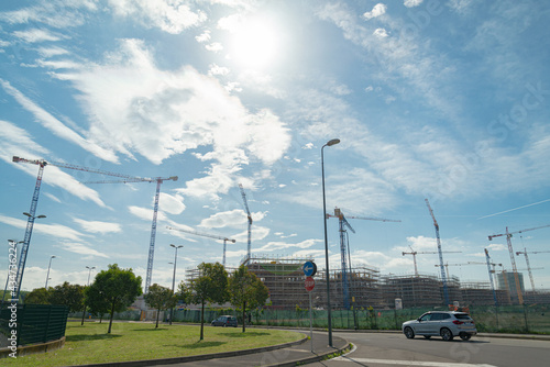 Silhouette of abig construction site with many cranes to build a new residential district in Milan, Italy, with several homes, named 