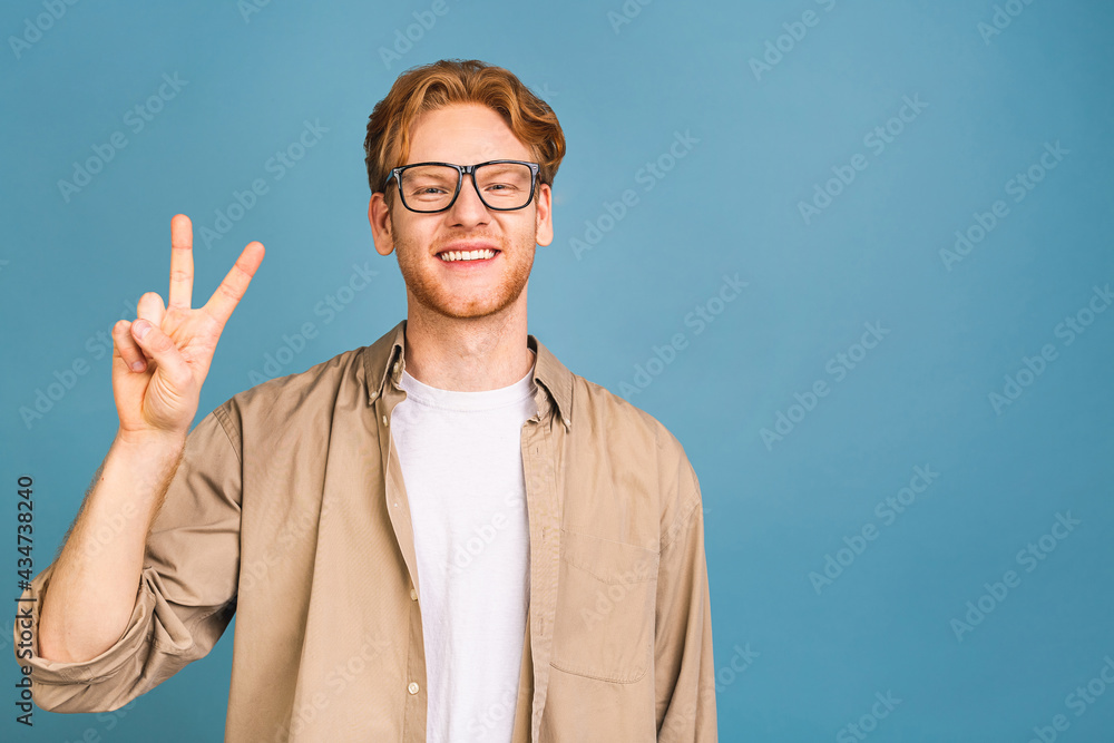 Headshot of attractive red-haired caucasian young business man wearing casual and glasses, isolated on blue background. Headshot of attractive red-haired caucasian young business man wearing casual and glasses, isolated on blue background.
