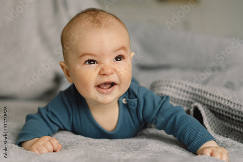 Cute newborn baby. Happy baby on a grey background.