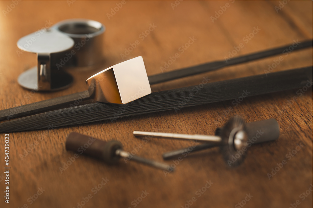 Blank logo ring, empty sterling golden ring, signet ring, initial ring and jeweler tools on wooden antique table. Blank logo ring, empty sterling golden ring, signet ring, initial ring and jeweler tools on wooden antique table.