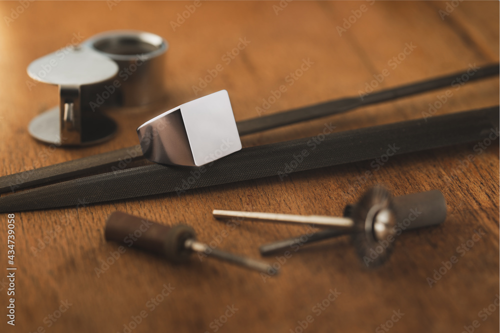 Empty signet silver ring and jeweler tools on wooden antique table. Tamplate for engraver, mockup. Empty signet silver ring and jeweler tools on wooden antique table. Tamplate for engraver, mockup.