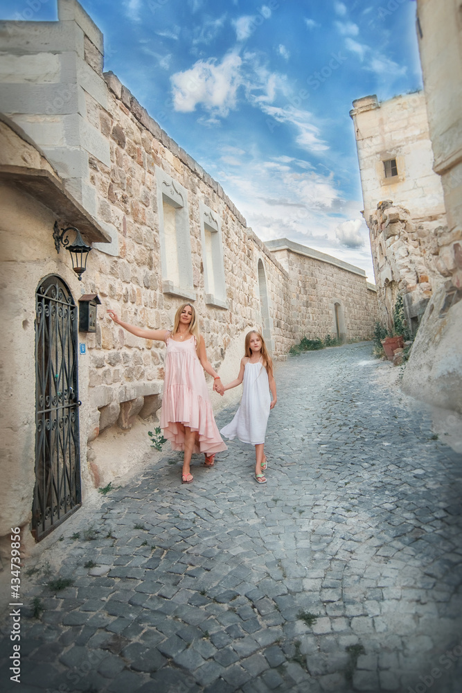 Mom and daughter walk along the narrow streets of Cappadocia. Journey. Turkey. Stroll. Adventures