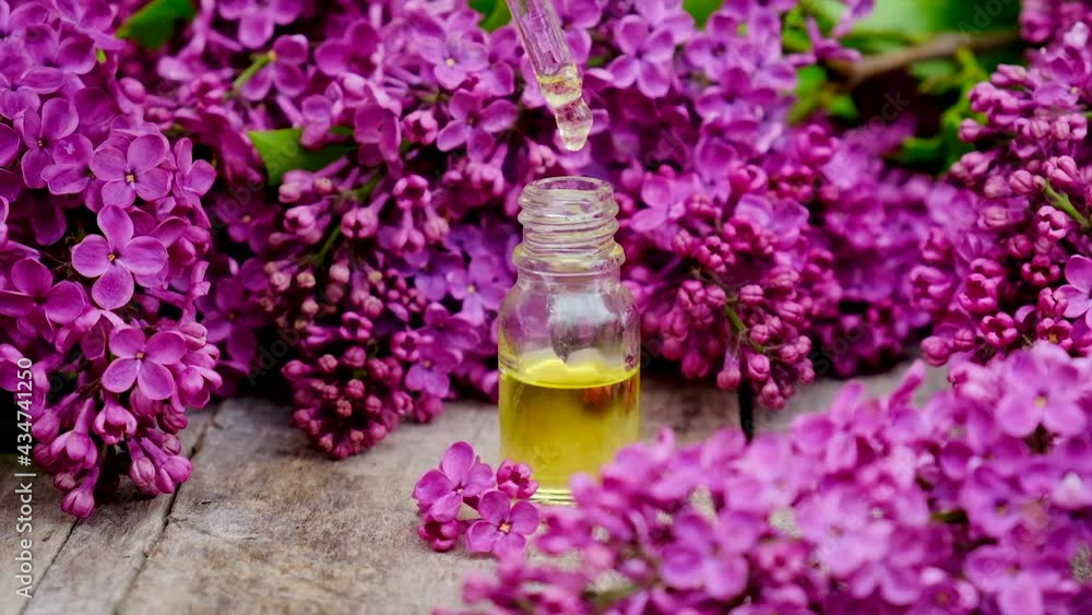 Lilac essential oil and extract in a small bottle. Selective focus. Lilac essential oil and extract in a small bottle. Selective focus.