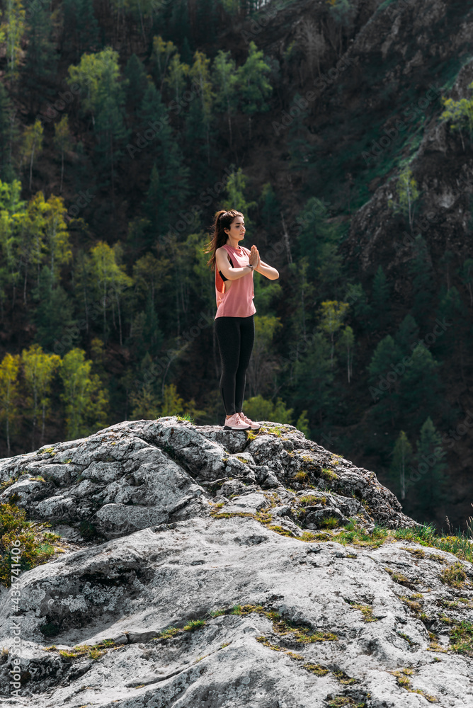 A slender woman does yoga exercises against an incredible backdrop of nature. The woman does yoga in the fresh air. Healthy and yoga concept. Meditation and Relax. Healthy Lifestyle. Copy space