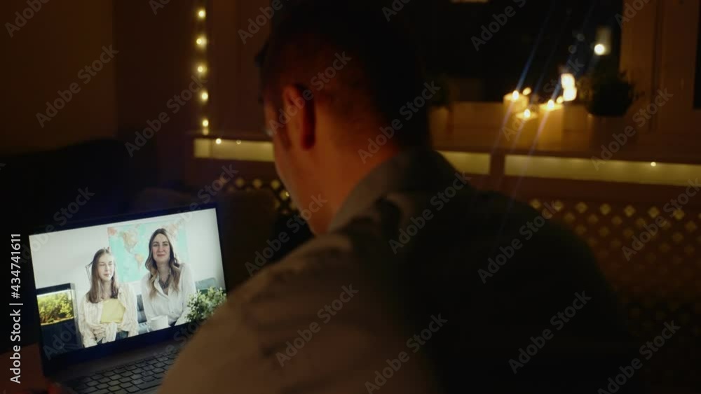 Man talking with his family in video chat at night. Time differences between time zones. Man talking with his family in video chat at night. Time differences between time zones.