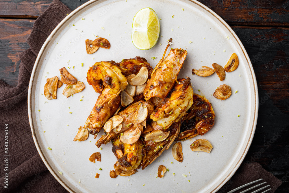 Grilled Mango Prawns or shrimps, on plate, on old dark  wooden table background, top view flat lay