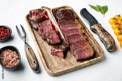 Grilled sliced t bone steak, on white stone  background photo