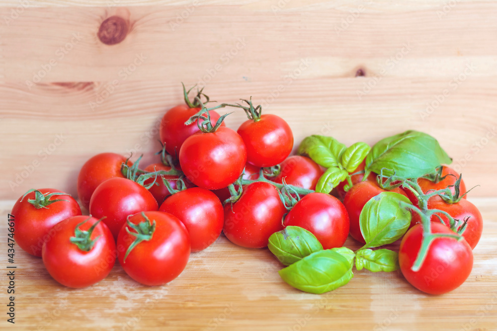 Red Cherry Tomatoes with Basil on a Wooden Background Red Cherry Tomatoes with Basil on a Wooden Background