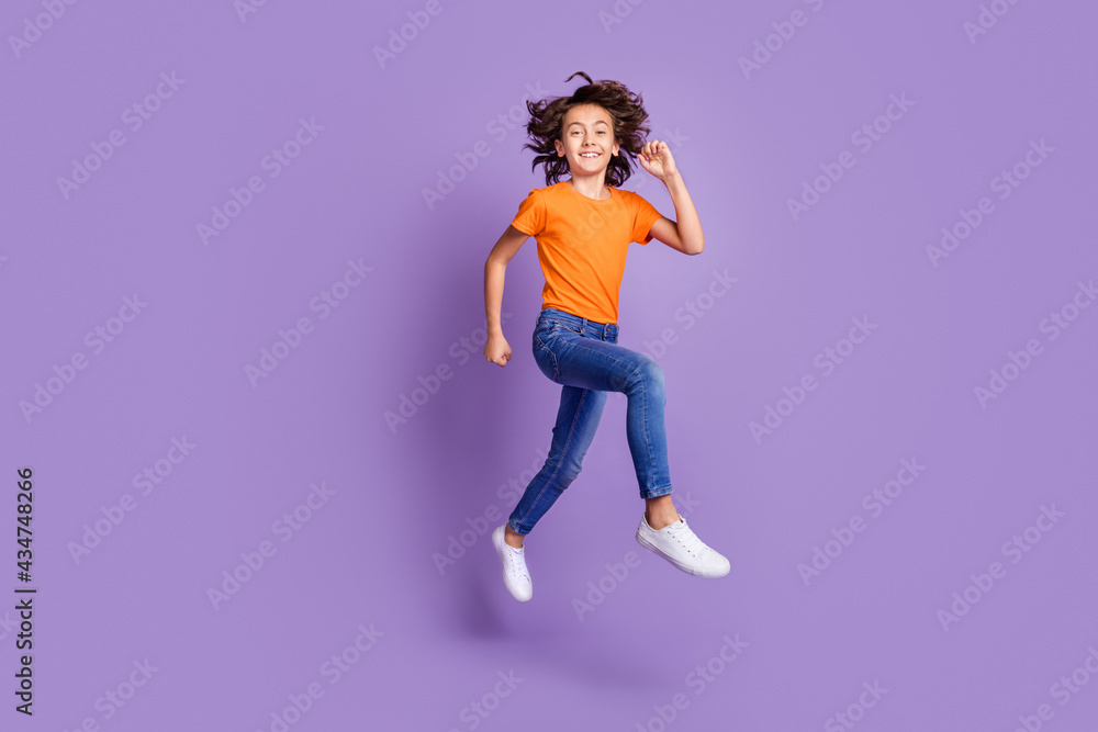 Full length body size view of attractive cheerful boy jumping having fun running isolated over violet purple color background