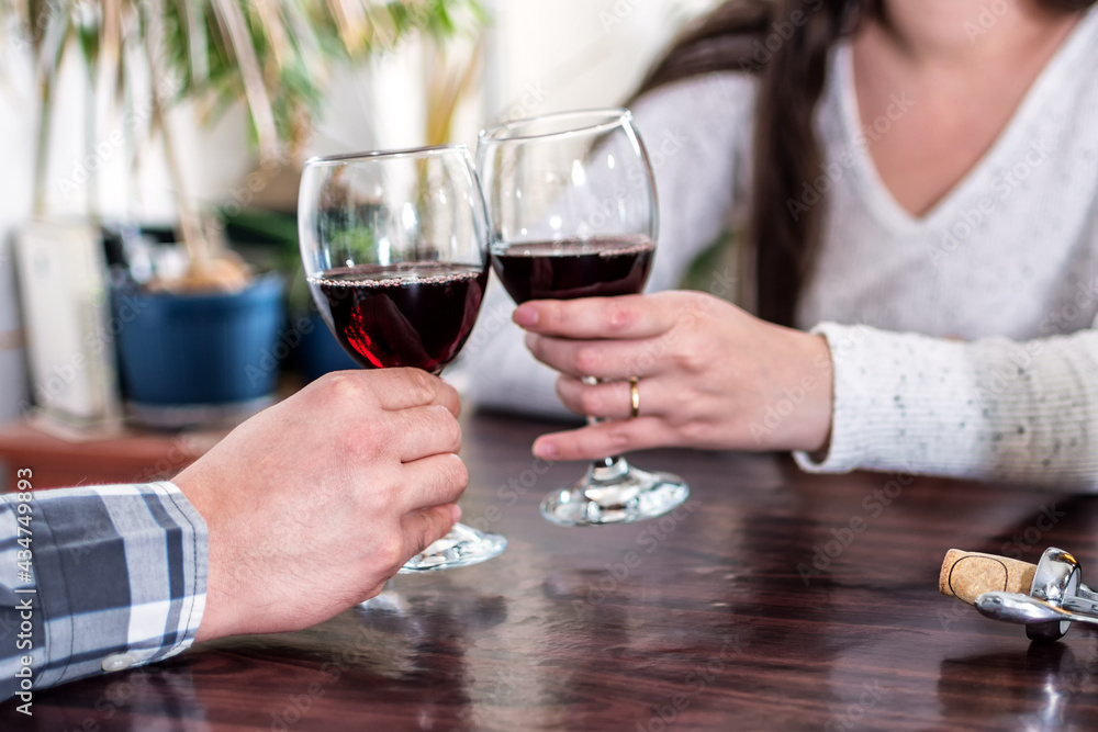 Close up of young couple toasting with glasses of red wine. Close up of young couple toasting with glasses of red wine.