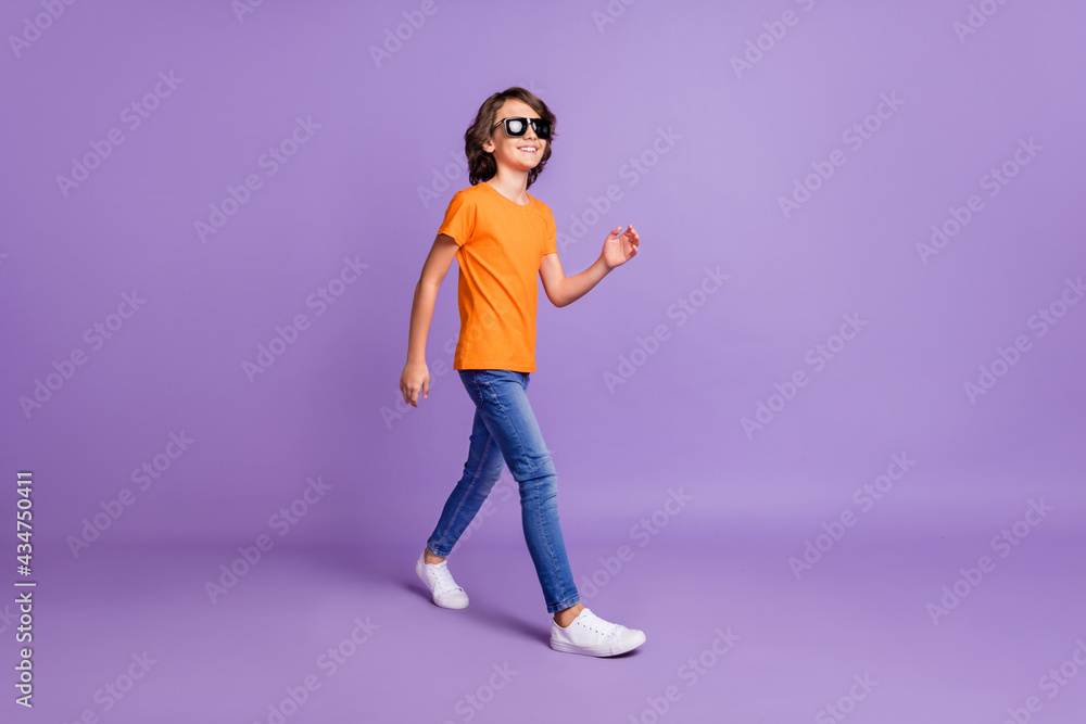 Full length body size view of attractive funky glad cheerful boy strolling isolated over violet purple color background