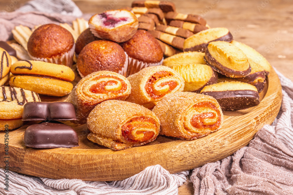 Assorted various cookies and muffins in wooden combination plate Assorted various cookies and muffins in wooden combination plate