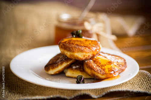 sweet fried cottage cheese pancakes with jam in a plate